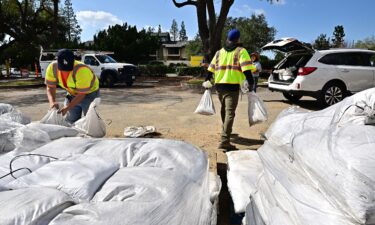 Pasadena residents load sandbags into their cars to prepare for the torrential rain in the forecast