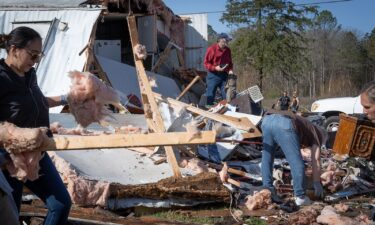 Calera Baptist church members pray before beginning clean up after the church was hit by a tornado on Sunday in Calera