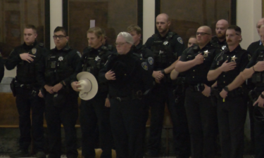 Officers show respect for the fallen as taps play the Peace Officer Memorial to a close.